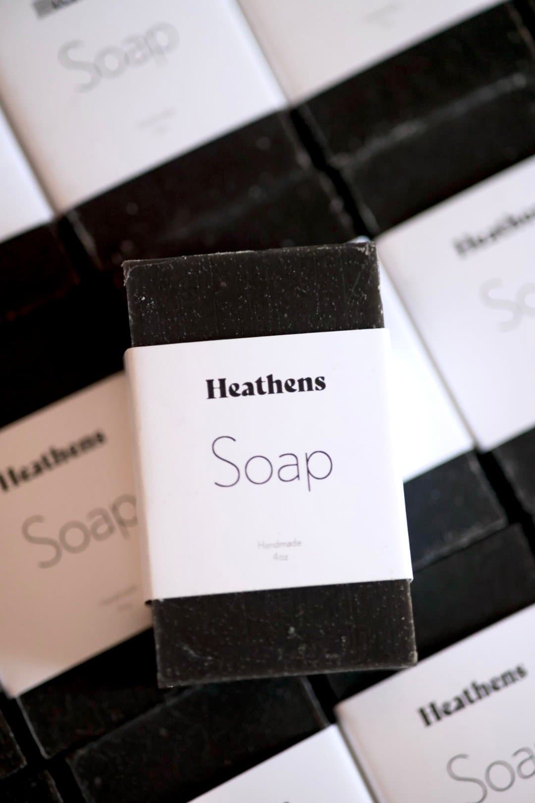 Heathens soap bars laid out in rows, black soap and white wraps.
