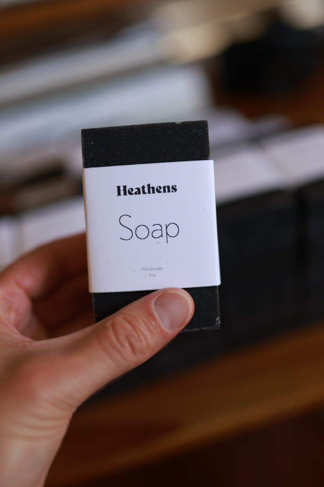 A hand holding a bar of Heathens soap.